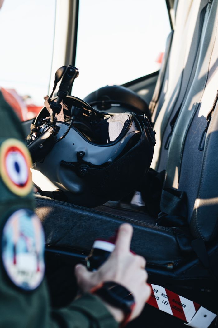 our-mission Close-up of a pilot's helmet on a seat inside an aircraft, showcasing aviation gear.