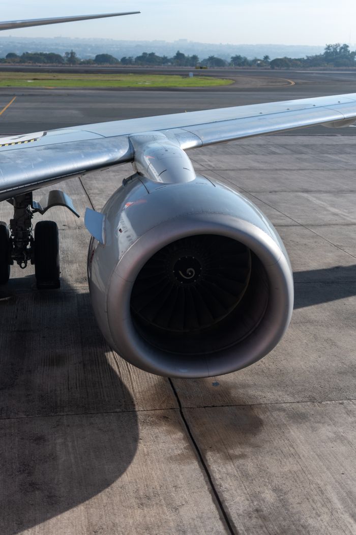 Detailed image of a jet engine on the airport runway, showcasing modern aviation technology.