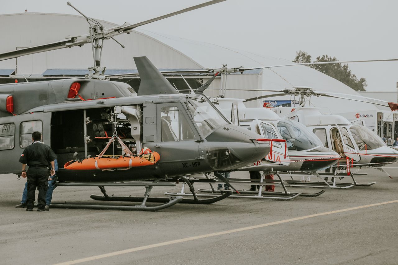 about-01 Helicopters displayed at an outdoor airshow with visible equipment and personnel.